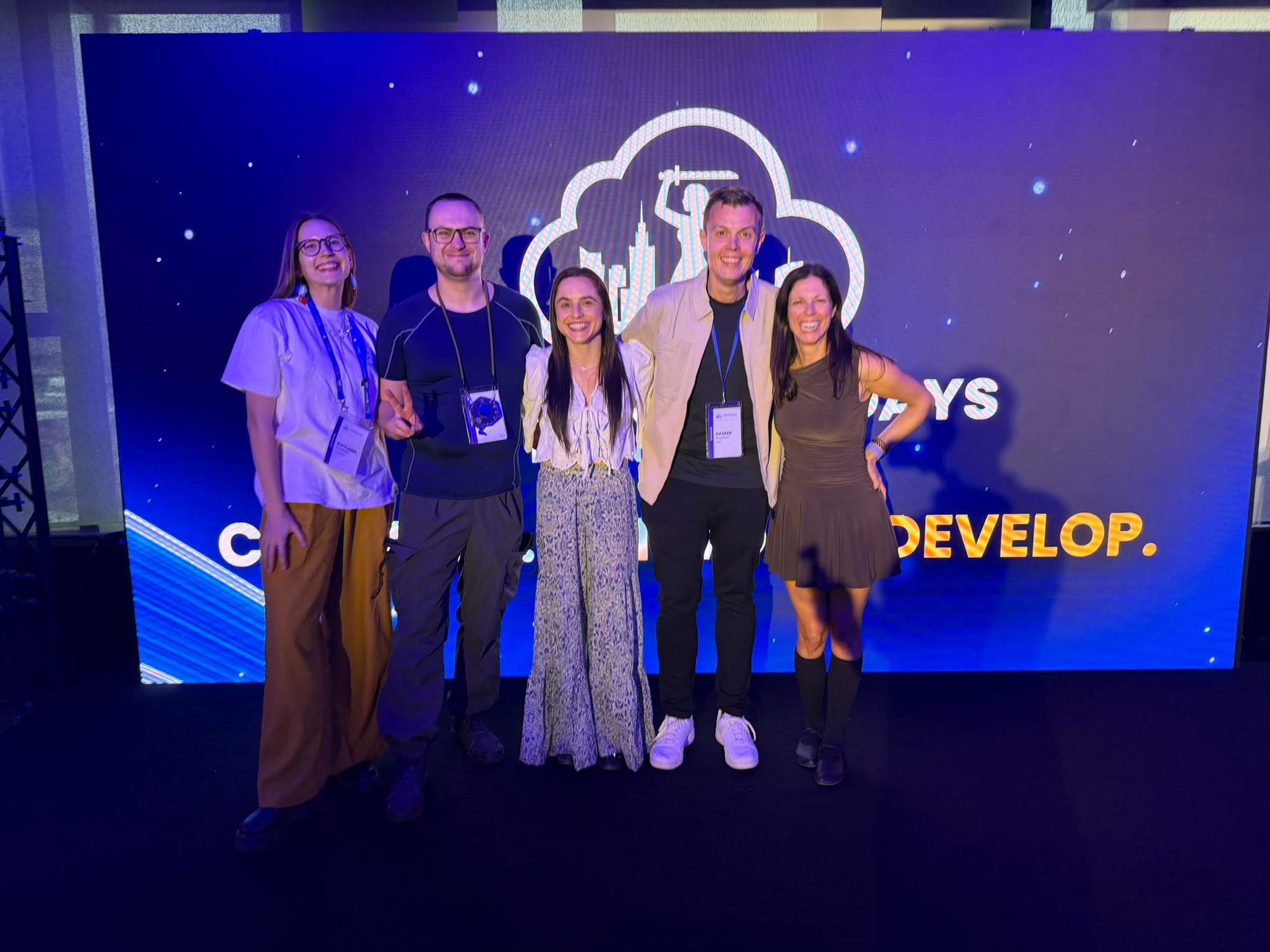 Svitlana, Marcus, Julia, Kasper and Adriana in front of the Cloud Native Days Poland backdrop