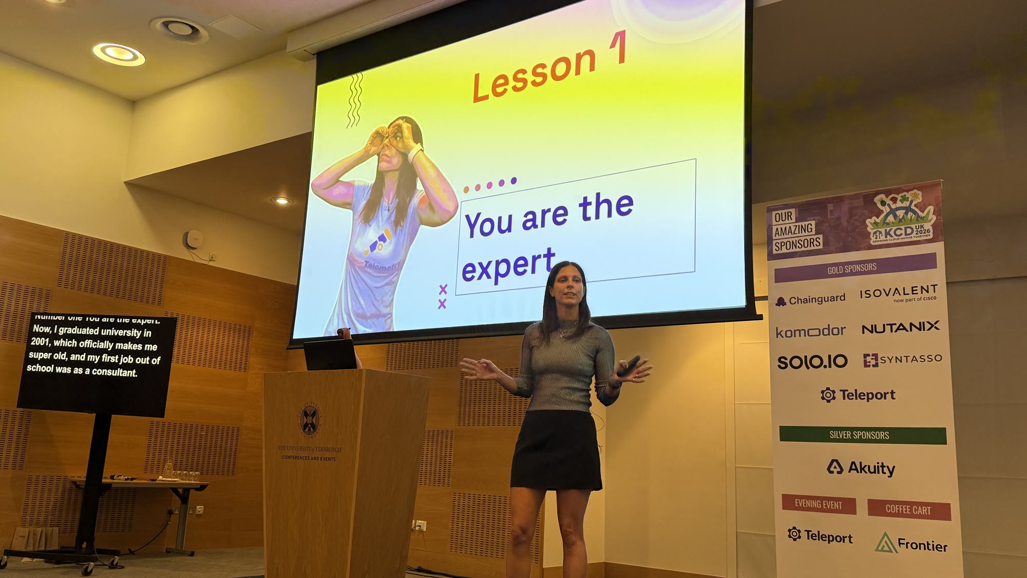 Adriana Villela on stage in front of a slide reading Lesson 1: You are the expert