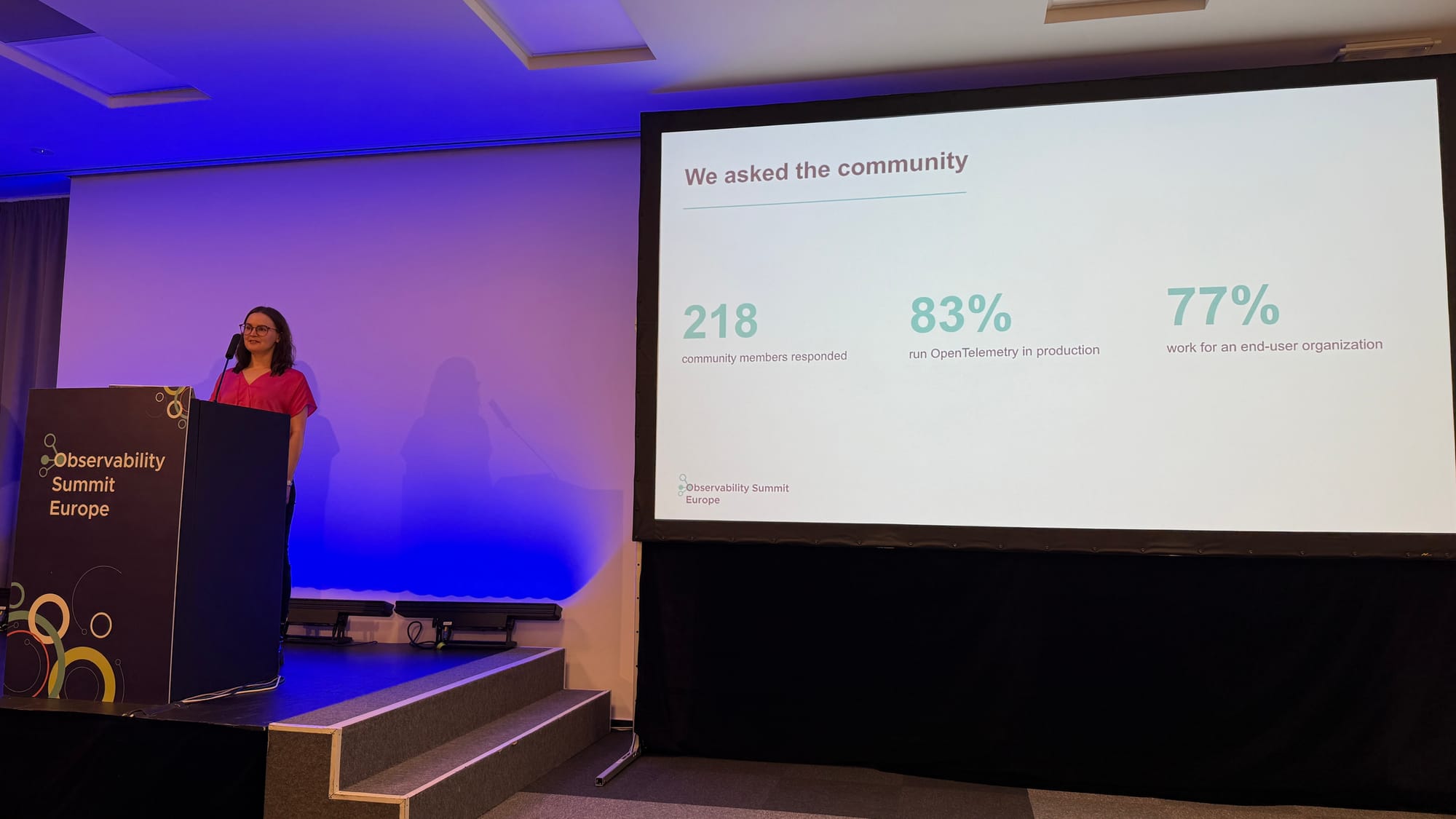 Johanna Öjeling giving her talk next to a slide: 218 community members responded, 83% run OpenTelemetry in production, 77% work for an end-user organization