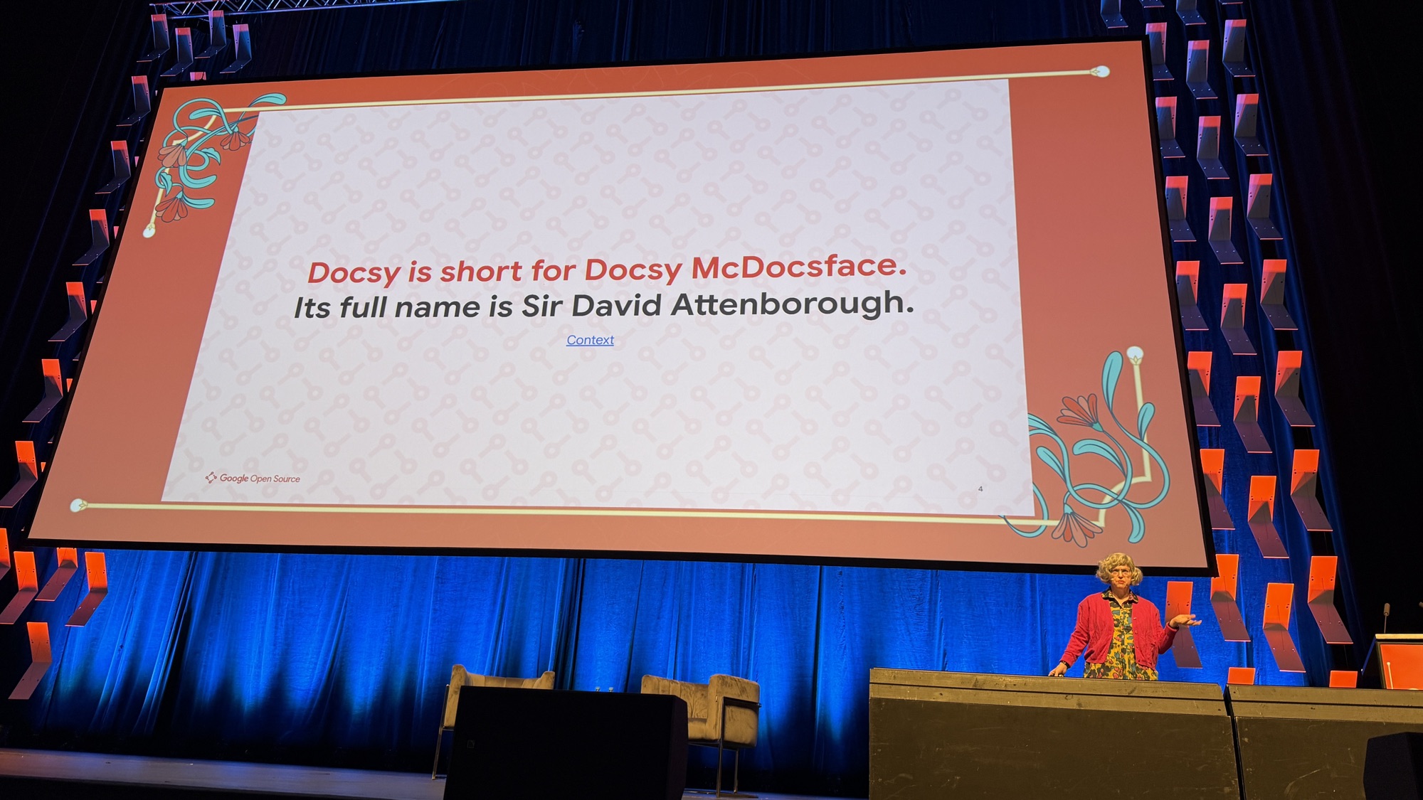 Erin McKean next to a slide reading: Docsy is short for Docsy McDocsface. Its full name is Sir David Attenborough.