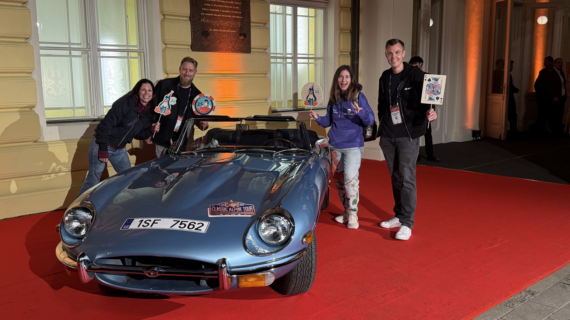 Adriana, Henrik, Diana and Kasper with party props around a classic blue convertible